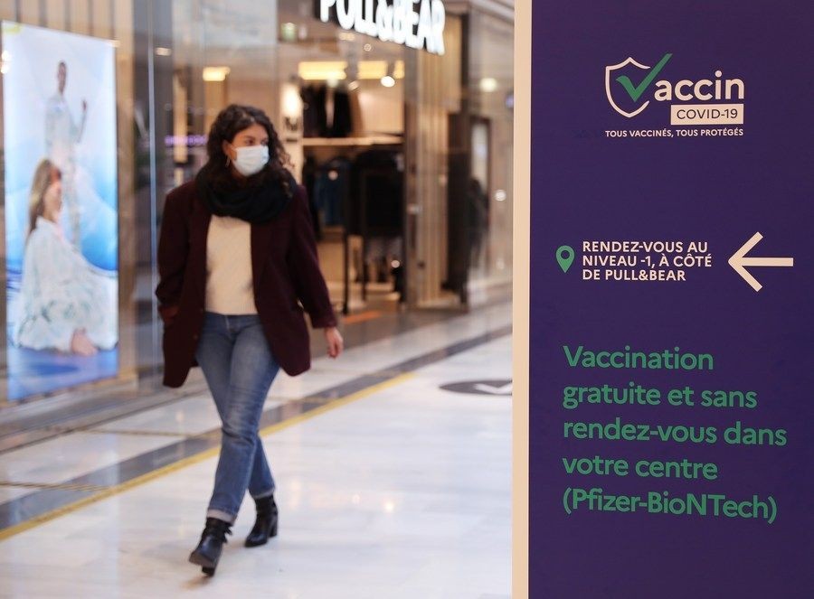 A customer walks past a sign indicating a COVID-19 vaccination center inside a shopping mall in Levallois-Perret near Paris, France, Nov. 9, 2021. (Xinhua/Gao Jing/IANS)